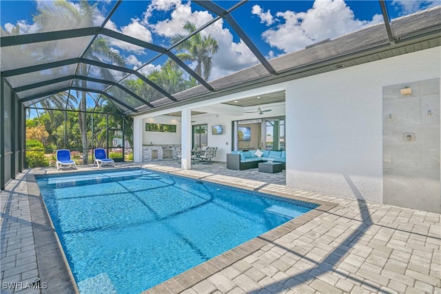 pool featuring glass enclosure, a patio, a ceiling fan, and outdoor lounge area