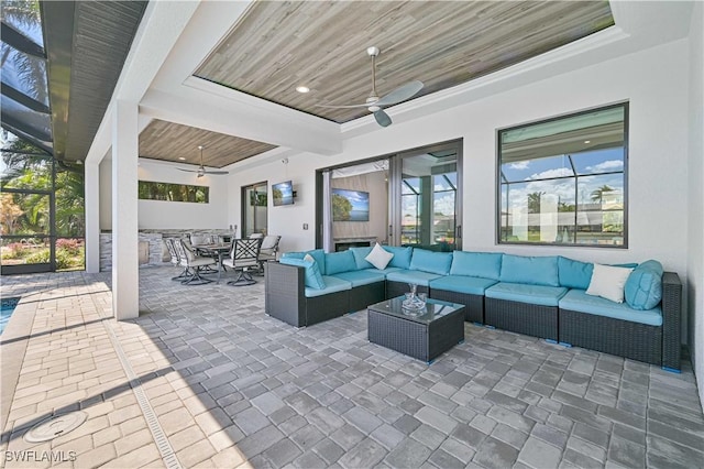 view of patio / terrace with glass enclosure, outdoor dining area, ceiling fan, and an outdoor hangout area