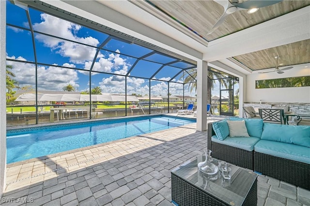 outdoor pool with a patio area, an outdoor living space, glass enclosure, and a ceiling fan