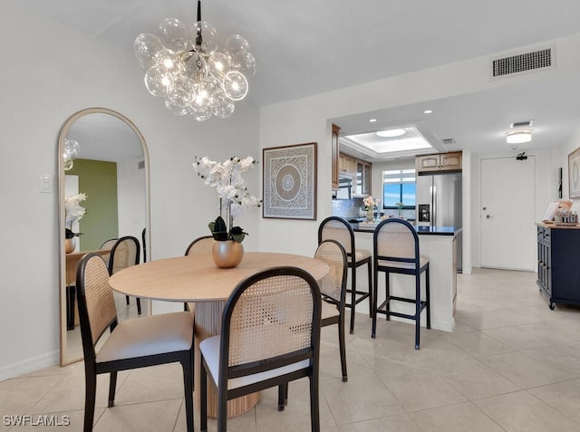 dining room with visible vents, a tray ceiling, light tile patterned floors, recessed lighting, and arched walkways