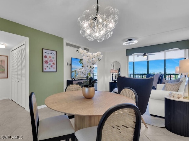 dining area featuring visible vents, light tile patterned flooring, a ceiling fan, and baseboards