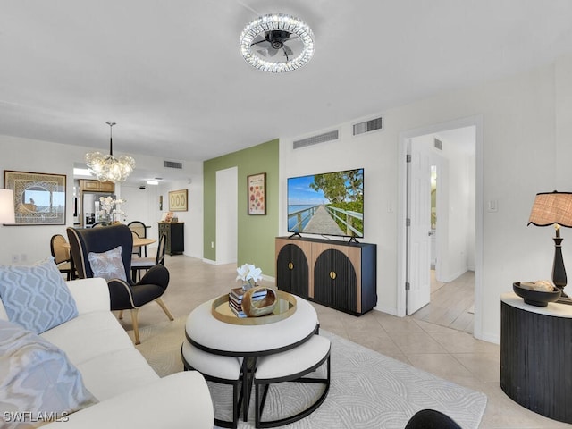 living room featuring light tile patterned flooring, visible vents, and an inviting chandelier