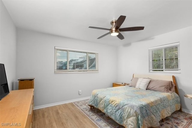 bedroom featuring baseboards, light wood-style flooring, and a ceiling fan