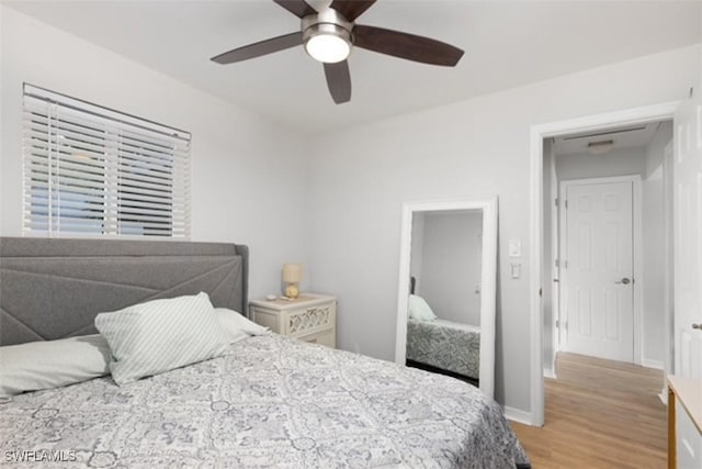 bedroom with a ceiling fan, light wood-style floors, and baseboards