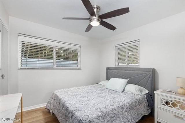 bedroom with ceiling fan, baseboards, and wood finished floors