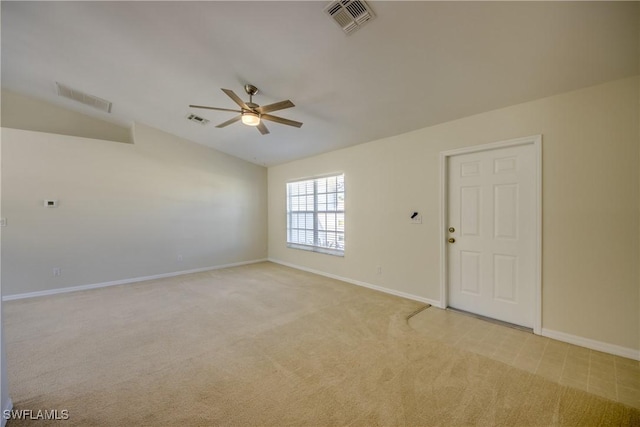 spare room with a ceiling fan, visible vents, and light carpet