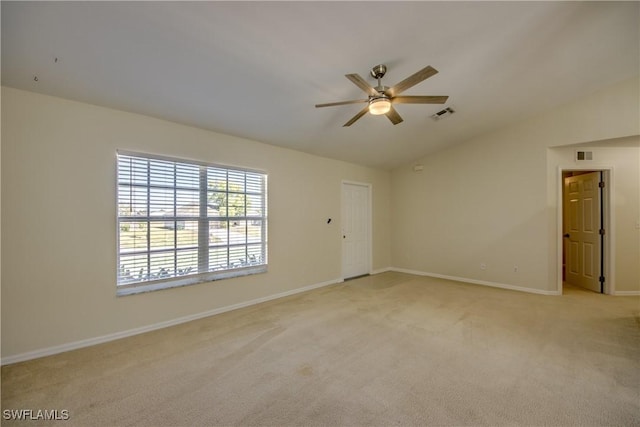 empty room with visible vents, lofted ceiling, light carpet, and ceiling fan