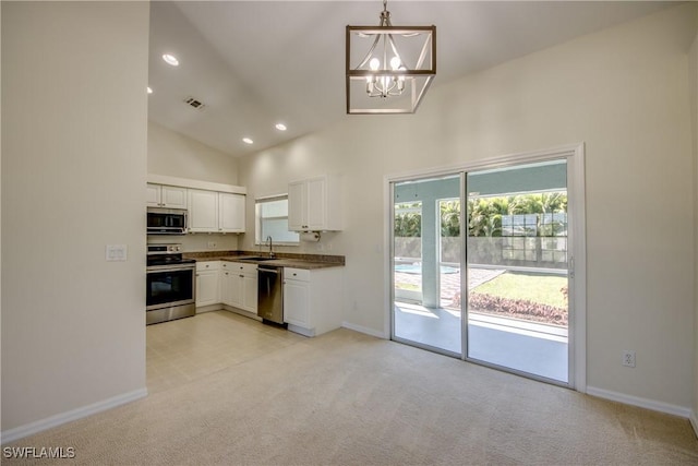 kitchen featuring dark countertops, visible vents, light carpet, appliances with stainless steel finishes, and white cabinets