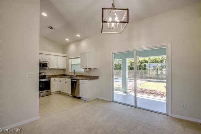 kitchen with visible vents, light carpet, a sink, appliances with stainless steel finishes, and white cabinets