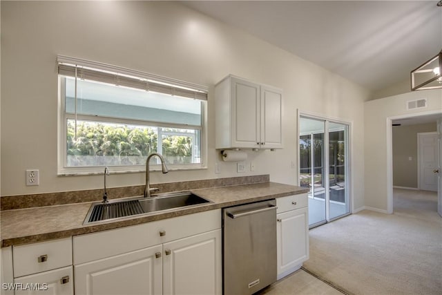 kitchen featuring visible vents, a sink, white cabinetry, dishwasher, and vaulted ceiling