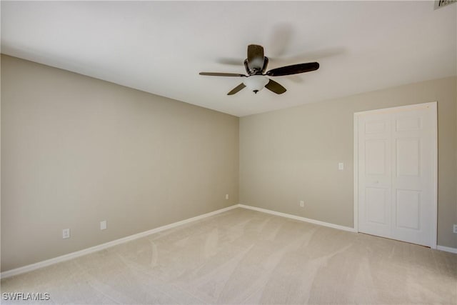 empty room with light carpet, visible vents, a ceiling fan, and baseboards