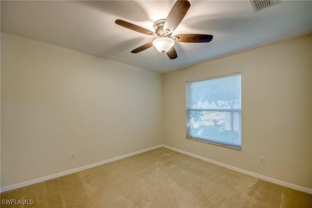 spare room featuring visible vents, baseboards, light colored carpet, and a ceiling fan