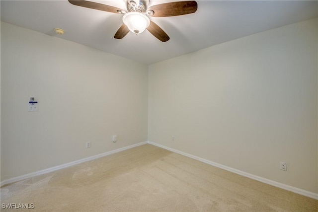 unfurnished room with baseboards, light carpet, and a ceiling fan