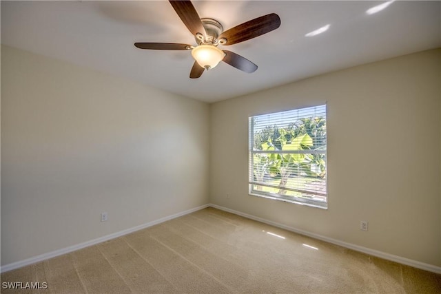 spare room featuring ceiling fan, baseboards, and light carpet