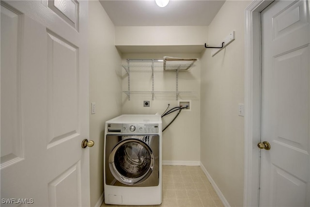 washroom featuring laundry area, washer / clothes dryer, and baseboards