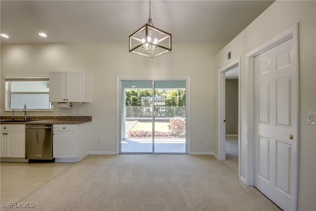 kitchen featuring dark countertops, light colored carpet, dishwasher, white cabinetry, and a sink