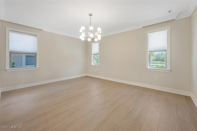 spare room featuring a wealth of natural light, light wood-style flooring, and crown molding