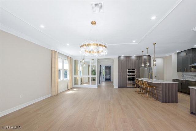 kitchen featuring visible vents, a breakfast bar, light countertops, appliances with stainless steel finishes, and modern cabinets