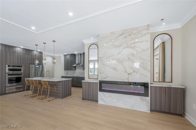 kitchen with stainless steel appliances, modern cabinets, wall chimney exhaust hood, and decorative backsplash