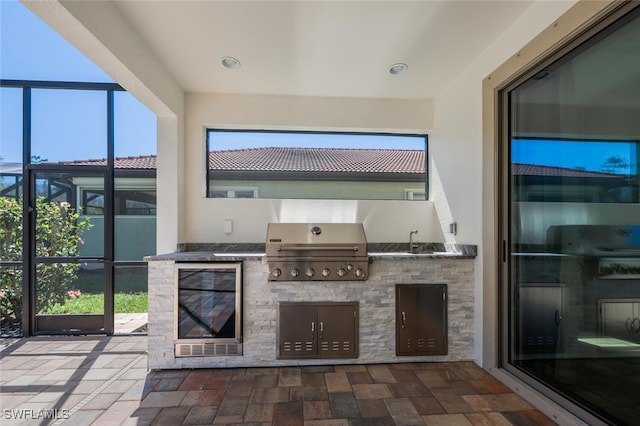 view of patio with a sink, a lanai, area for grilling, and grilling area
