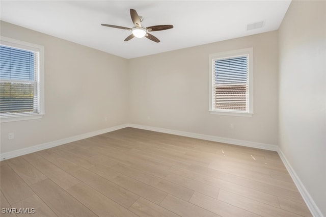 spare room with visible vents, plenty of natural light, light wood-style floors, and ceiling fan