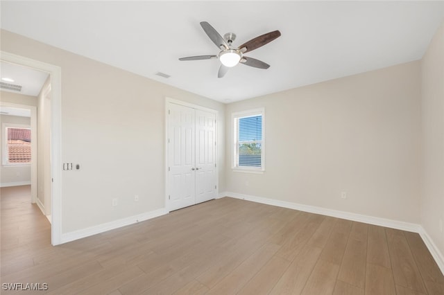 unfurnished bedroom featuring a closet, visible vents, baseboards, and light wood finished floors