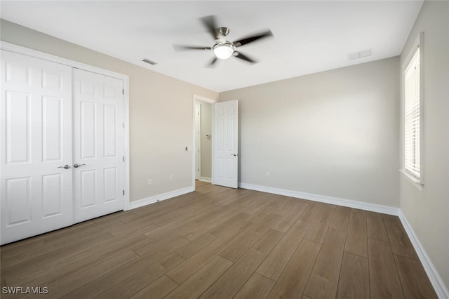 unfurnished bedroom featuring wood finished floors, visible vents, and baseboards