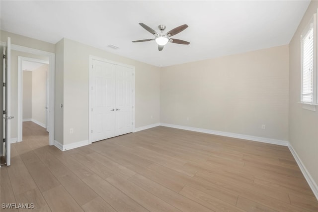 unfurnished bedroom with visible vents, a closet, light wood finished floors, baseboards, and ceiling fan