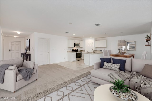 living area featuring recessed lighting, visible vents, and light carpet