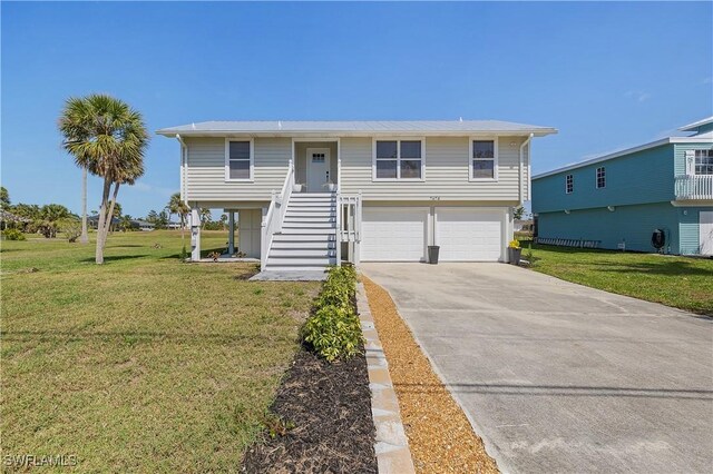 view of front of home featuring stairs, a front yard, a garage, and driveway