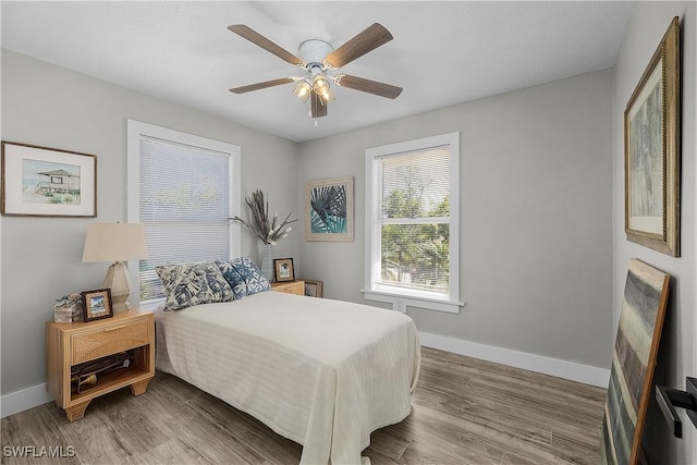 bedroom featuring a ceiling fan, wood finished floors, and baseboards