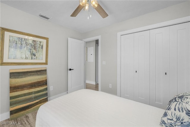 bedroom with baseboards, wood finished floors, a closet, and ceiling fan