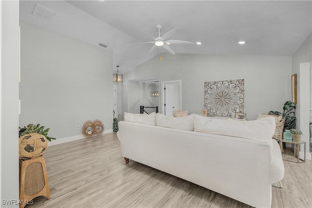 living area with visible vents, light wood-style flooring, ceiling fan, and vaulted ceiling