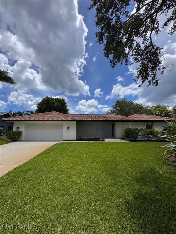 145 Forestwood Dr, Naples, FL 34110 - ranch-style home with a tile roof, stucco siding, a garage, and a front yard