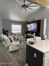 interior space featuring vaulted ceiling, dark wood-style floors, and ceiling fan