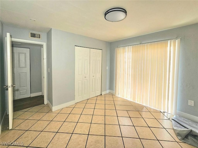 5529/5531 10th Ave, Fort Myers, FL 33907 - unfurnished bedroom with a closet, light tile patterned floors, and baseboards