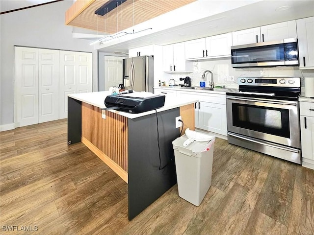 5529/5531 10th Ave, Fort Myers, FL 33907 - kitchen with appliances with stainless steel finishes, a sink, a kitchen island, wood finished floors, and white cabinetry