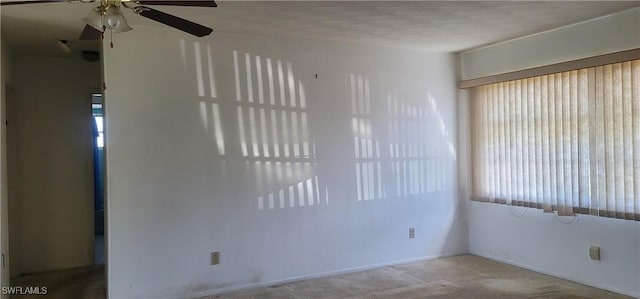 carpeted empty room with a ceiling fan