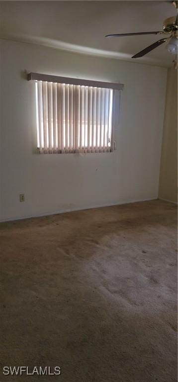 carpeted spare room with a wealth of natural light and ceiling fan