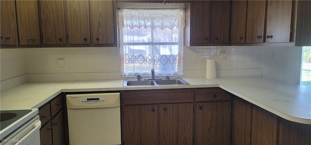 kitchen with a sink, backsplash, dishwasher, light countertops, and range