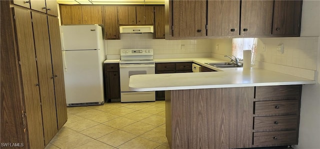 kitchen featuring tasteful backsplash, light countertops, exhaust hood, white appliances, and a sink