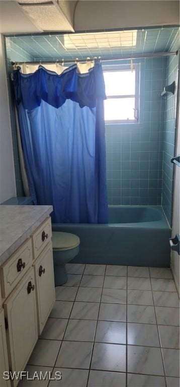 full bathroom featuring tile patterned floors, toilet, vanity, and shower / bathtub combination with curtain