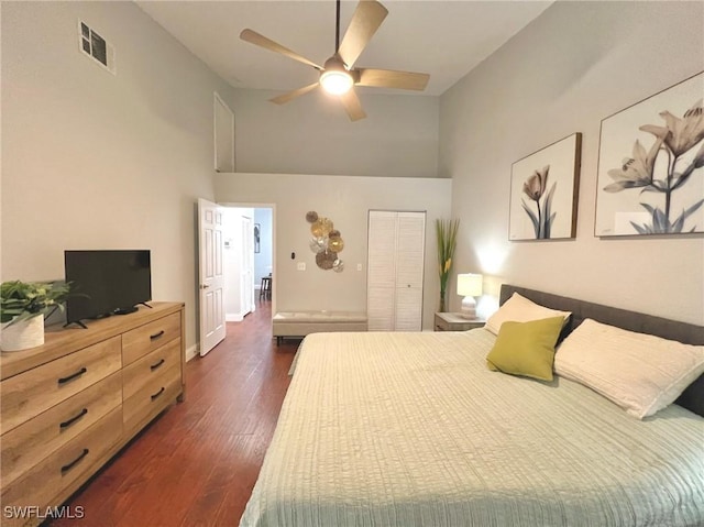 bedroom with visible vents, a closet, dark wood-style flooring, high vaulted ceiling, and a ceiling fan