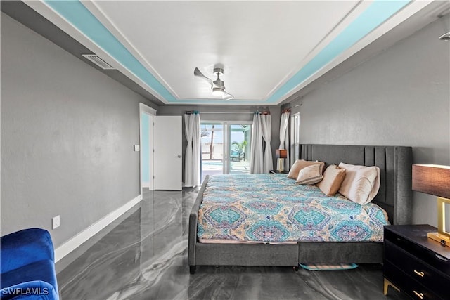 bedroom with visible vents, baseboards, and a raised ceiling