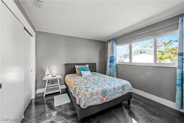 bedroom with a closet, visible vents, and baseboards