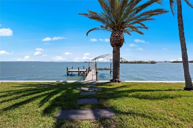 view of dock featuring boat lift, a lawn, and a water view