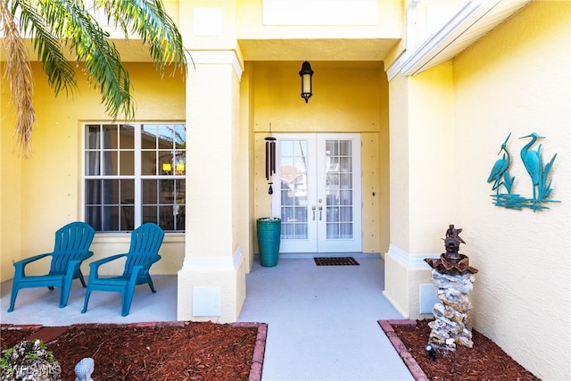 property entrance with stucco siding and french doors