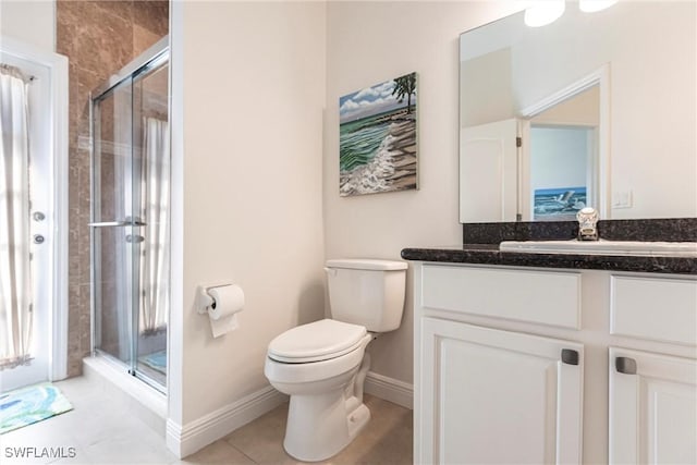 full bathroom featuring baseboards, toilet, a stall shower, tile patterned floors, and vanity