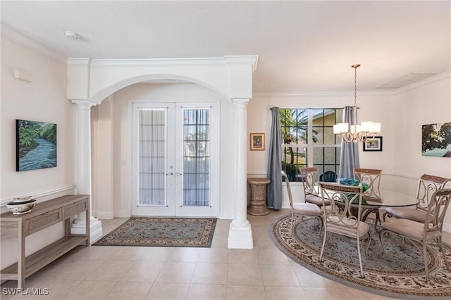 entrance foyer with arched walkways, french doors, crown molding, and an inviting chandelier