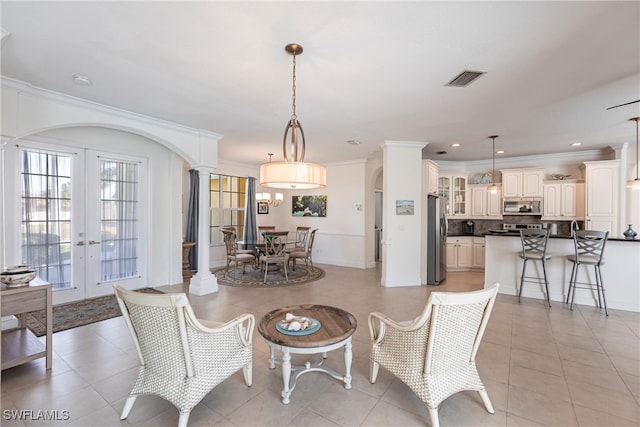 dining space with visible vents, french doors, crown molding, light tile patterned floors, and ornate columns